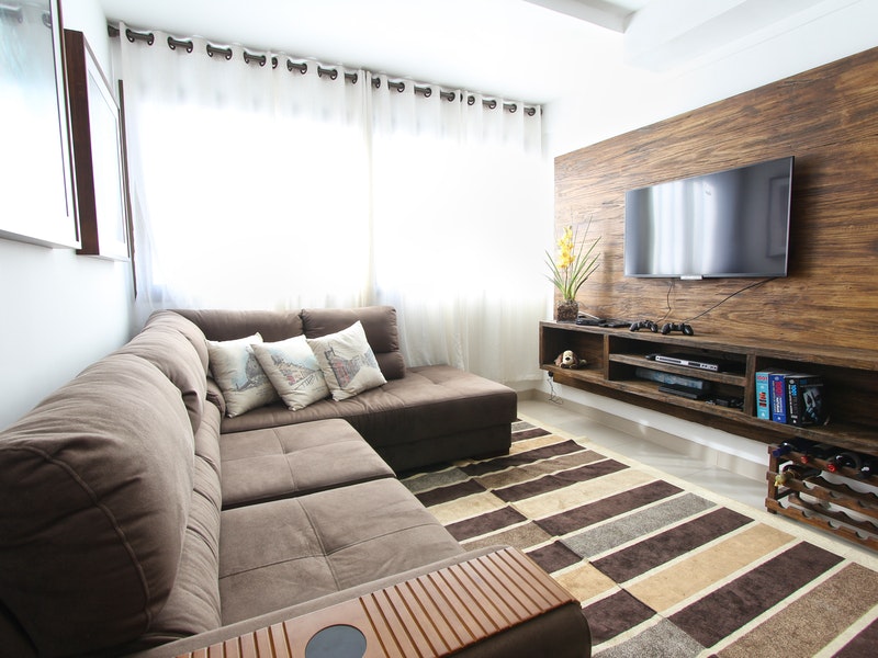 Tv en el mueble en una habitación oscura con una pared de madera